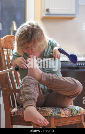 Frau mit TAR-Syndrom herauf etwas mit ihren Füßen Stockfoto