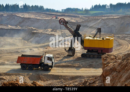 Dump Truck in der industriellen Bergbau Steinbruch. Der Bagger Ladungen Sand in eine schwere Kipper für den Transport in der brecheranlage und Versand der Sor Stockfoto