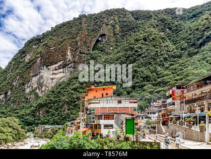 Aguas Caliente, Peru - April 8, 2019: Blick auf die Häuser in der Stadt Aguas Caliente, der Eisenbahn und der Phutuq K'Usi, Putucusi, Berg an Stockfoto