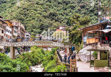 Aguas Caliente, Peru - April 8, 2019: Blick auf die Häuser, Brücken und den Fluss auf der Hauptstraße in der Stadt Aguas Caliente in Peru. Stockfoto