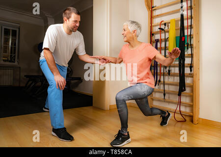 Ältere Frau Ausfallschritte machen Stockfoto