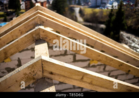 Close-up Detail der Dachrahmen aus grobem Holz Bauholz Balken auf dem Hintergrund von Misty Mountain Landschaft im ökologischen Bereich. Gebäude, Dach, constructi Stockfoto