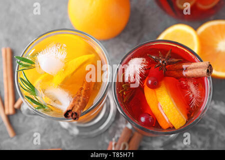 Leckere Getränke mit Orange und Zimt in Glas Tassen auf dem Tisch Stockfoto