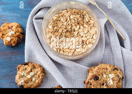 Glas mit Haferflocken und leckeren Cookies auf Holz- Hintergrund, Ansicht von oben Stockfoto