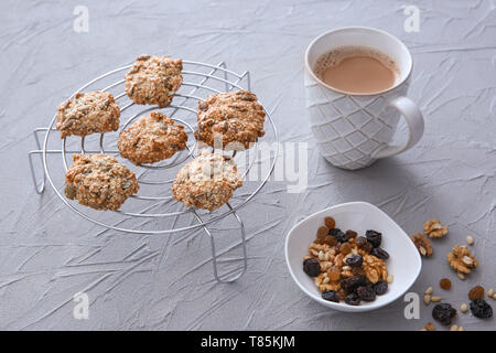 Kühlung Rack mit Haferflocken Cookies und Tasse Kaffee auf strukturierten Hintergrund Stockfoto