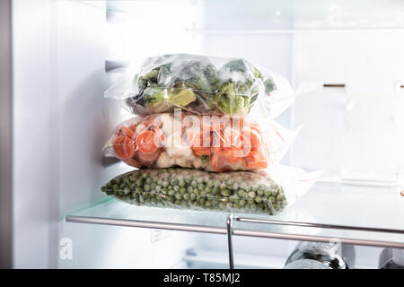 Plastiktaschen mit verschiedenen Gefrorenes Gemüse essen im Kühlschrank Stockfoto