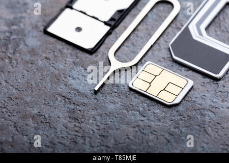 Nano-SIM-Karte in den Card Adapter mit Eject Pin auf Betonoberfläche Stockfoto