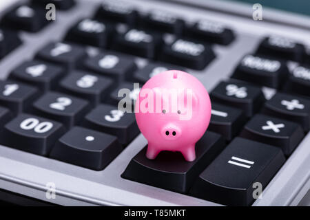 In der Nähe von kleinen rosa Sparschwein auf Rechner Stockfoto