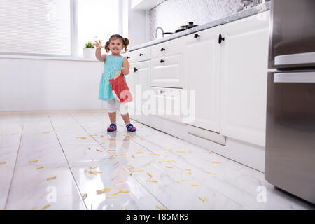 Lächelnde Mädchen werfen Pommes Frites In der Küche Stockfoto