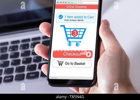 Die menschliche Hand Handy mit Online Shopping Anwendung Stockfoto
