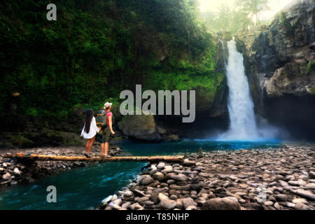 Junges Paar steht am Bach, mit Mann Fotografieren des Wasserfalls. Zwei Touristen, die in der Natur zu genießen. Stockfoto