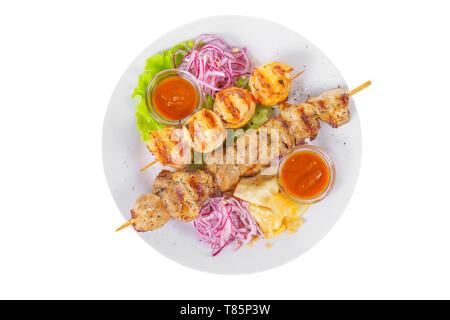 Shish Kebab auf dem Grill mit eingelegten Zwiebeln, Kohl und Ketchup, Tomatensauce auf einem Teller, auf weißem Hintergrund, Ansicht von oben Stockfoto