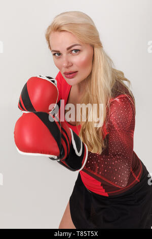 Porträt der jungen Athleten blonde Frau in Boxhandschuhen auf grauem Hintergrund posiert Stockfoto