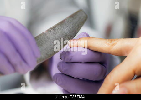 Feilen Fingernägel im Nagelstudio Stockfoto