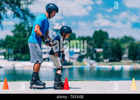 Großvater lehre Enkel zu Roller Skate Stockfoto