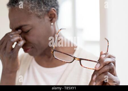 Frau berühren der Nasenrücken Stockfoto