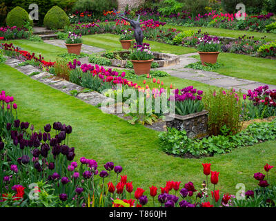 Chenies Manor versunkenen Garten mit Pavillon und Teich Anfang Mai zeigen bunte Tulpen, Skulptur und frische grüne Blätter wunderschön gestaltet. Stockfoto