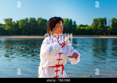 Frauen üben von Tai Chi am See Stockfoto