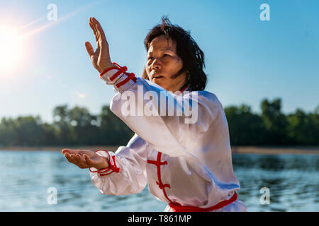 Frauen üben von Tai Chi am See Stockfoto