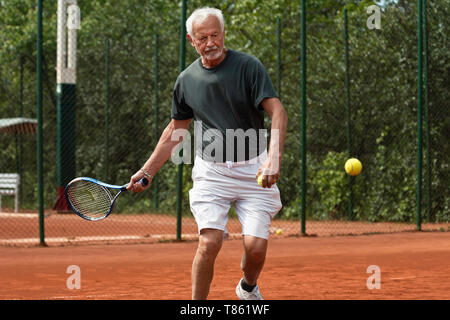 Aktiven senior Mann Tennis spielen Stockfoto