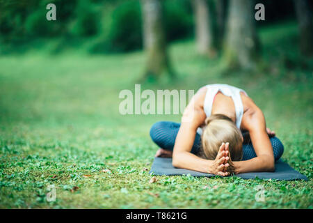 Yoga nach vorne sitzt Bend Stockfoto