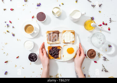 7/8-Ansicht von Frau mit Tattoo in der hand Halteplatte mit Frühstück auf Weiß Stockfoto