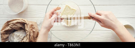 Panorama-aufnahme der Frau schneiden Butter in der Schüssel auf dem Tisch mit den Zutaten Stockfoto