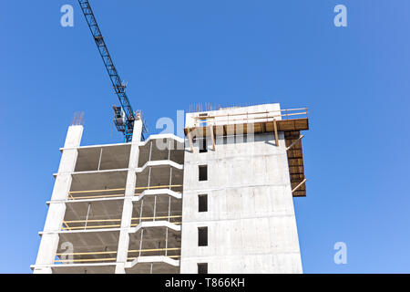 Apartment Gebäude im Bau mit Tower crane gegen den blauen Himmel Hintergrund Stockfoto