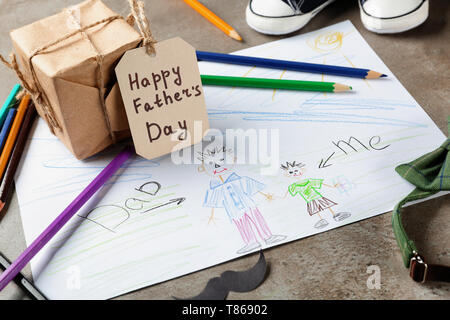 Zusammensetzung mit Zeichnung des Kindes und Geschenk Box auf dem Tisch. Der glückliche Vater Tag Feier Stockfoto