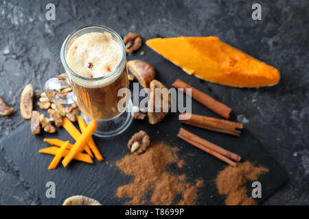 Glas Tasse Latte mit Zimt und Kürbis auf schiefer Platte Stockfoto