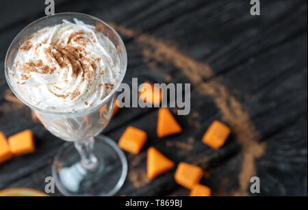 Glas Latte mit Zimt und Kürbis auf hölzernen Tisch Stockfoto