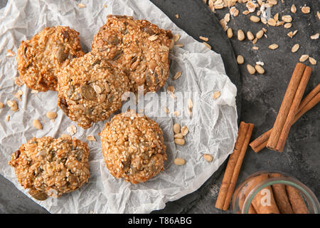 Schiefer Teller mit leckeren oatmeal Cookies auf grauem Hintergrund Stockfoto