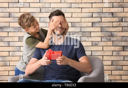 Mann, Geschenk für Vatertag von seinem Sohn zu Hause Stockfoto