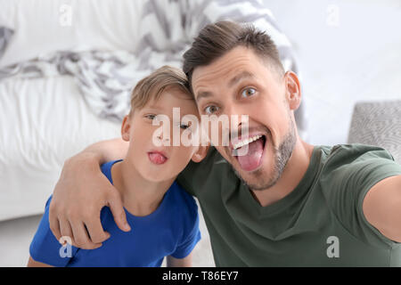 Kleiner Junge mit seinem Vater unter selfie zu Hause Stockfoto