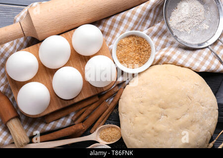 Zusammensetzung mit rohen Teig und Zutaten für die Zubereitung von Gebäck auf dem Tisch Stockfoto