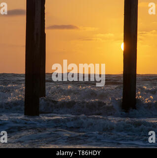 Sonnenaufgang am Claremont Pier mit Wellen über den super-Struktur brechen, Lowestoft Stockfoto