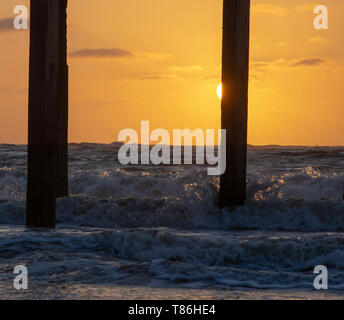 Sonnenaufgang am Claremont Pier mit Wellen über den super-Struktur brechen, Lowestoft Stockfoto