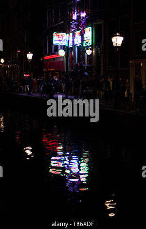 Neonlicht Reflexionen über Canal Oudezijds Achterburgwal in Amsterdam, Niederlande Stockfoto
