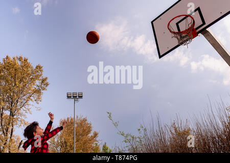 Körper Teil der dynamischen jungen Jungen mit erhobenen Armen schießen einen Basketball, horizontal Komposition, kopieren Raum Stockfoto