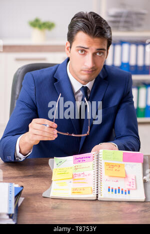 Jungen gutaussehenden Mitarbeiter Planung seine Tätigkeit Stockfoto