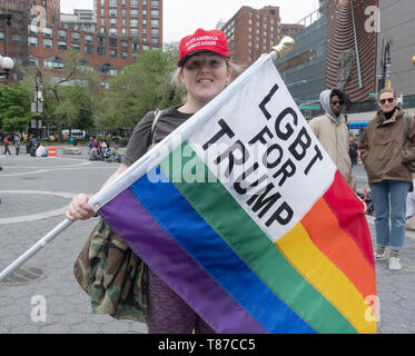 Eine transgender Frau bekleidet MAGA Hut und Holding und LGBT FÜR TRUMPF Regenbogen Flagge. Parkin in Union Square in Manhattan. Stockfoto