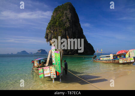 AO NANG (KRABI), Thailand - Januar 3. 2017: Blick auf isolierte Felsen in der Andaman See mit Long Tail Boot im flachen Wasser mit Getränken und Thai Essen Stockfoto