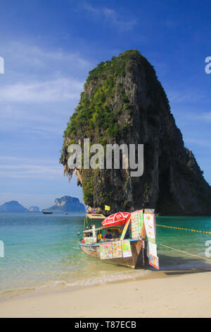 AO NANG (KRABI), Thailand - Januar 3. 2017: Blick auf isolierte Felsen in der Andaman See mit Long Tail Boot im flachen Wasser mit Getränken und Thai Essen Stockfoto