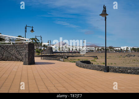 Promenade bauen aus schwarzer Lava sones Entlang der Playa Grande in Puerto del Carmen, Lanztarote, Spanien Stockfoto