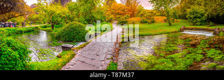 Die verzauberte Eden Garden Brücke über den Teich in horizontaler Panoramablick Nymphe Garten oder Giardino della Ninfa in Latium - Italien. Stockfoto