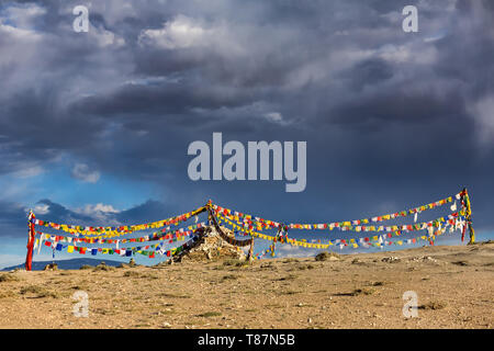 Alte Stein Stupa mit tibetischen Gebetsfahnen in Ladakh, Indien. Stockfoto