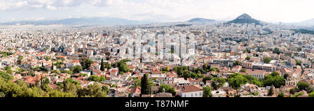 Athen Akropolis Panoramablick auf die Stadt einschließlich Lycabettus Hill Griechenland / ATHEN, Griechenland - Ein weites Panorama von der historischen Akropolis aus nimmt die gesamte Breite von Athen mit Lycabettus Hill erhebt sich deutlich über der städtischen Weite. Dieses UNESCO-Weltkulturerbe, Heimat des Parthenon und anderer klassischer Bauten, steht seit mehr als 2.500 Jahren über der griechischen Hauptstadt. Der atemberaubende Blick fängt den Kontrast zwischen der alten Zitadelle oben und der modernen mediterranen Metropole ein, die sich über das Attika-Becken erstreckt. Stockfoto