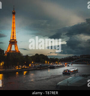 Blick auf die Seine und den Eiffelturm unter einem dunklen Sonnenuntergang in Paris. Stockfoto