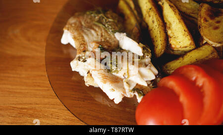 Fischgericht - Gebratenes Fischfilet mit Bratkartoffeln und Gemüse mit Gewürzen und Rosmarin, Ansicht von oben, kopieren Raum Stockfoto