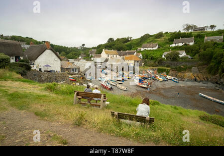 Man saß gerade traditionelle Fischerboote am Strand des kleinen Fischerdorfs Cadgwith, Cornwall, England, Großbritannien. Stockfoto